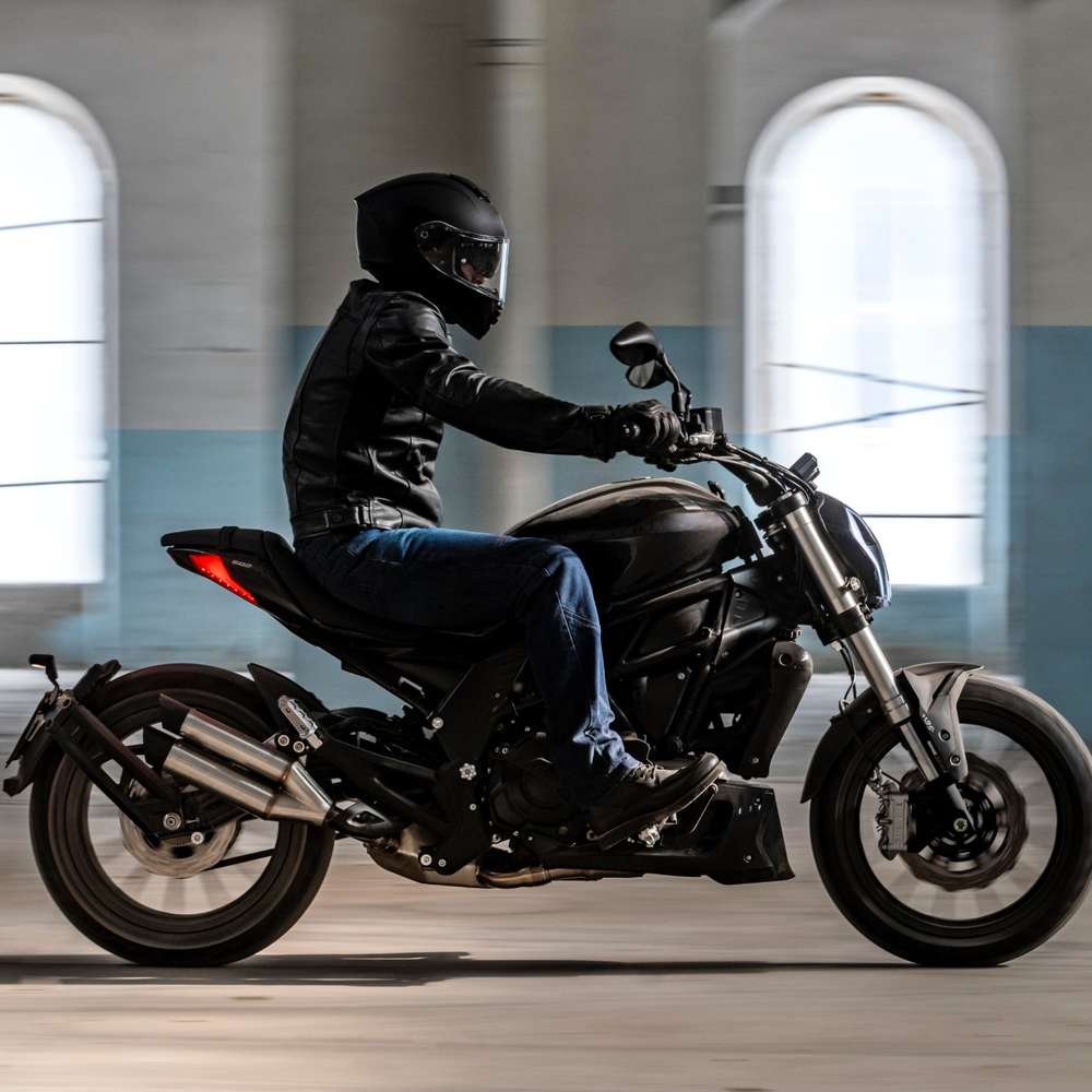 Benelli 502C in Schwarz seitlich fahrend in einer Halle fotografiert