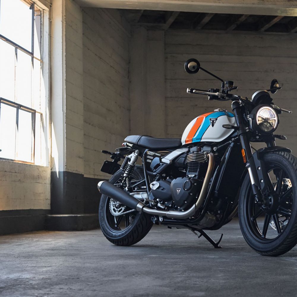 Triumph Speed Twin 900 für 2025 in Weiß und Orange stehend schräg von vorne