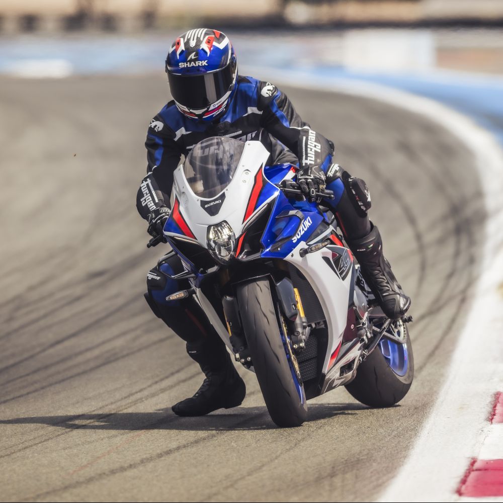 Die neue Suzuki GSX-R1000R Modelljahr 2026 in Blau-Weiß-Rot auf der Rennstrecke fahrend vor der Kurve im Slide