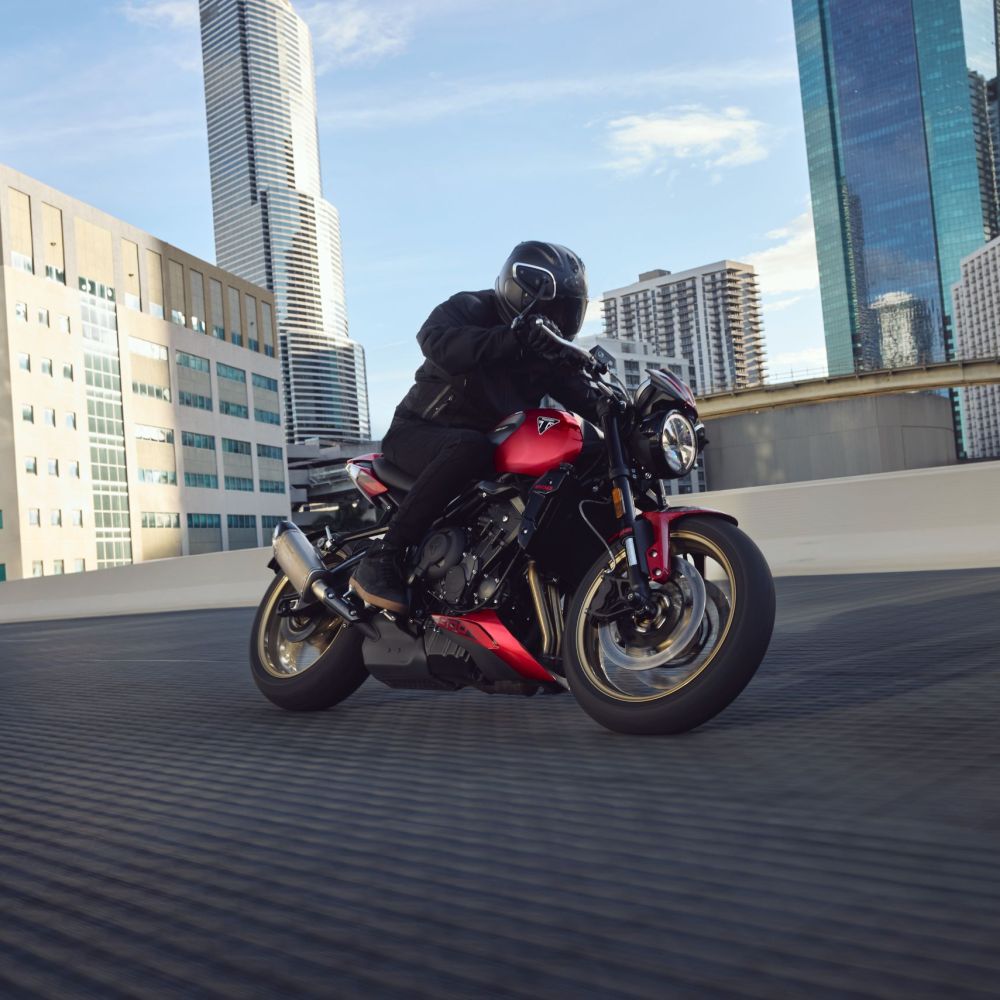 Die neue Triumph Trident 800 in Rot fahrend in Schräglage