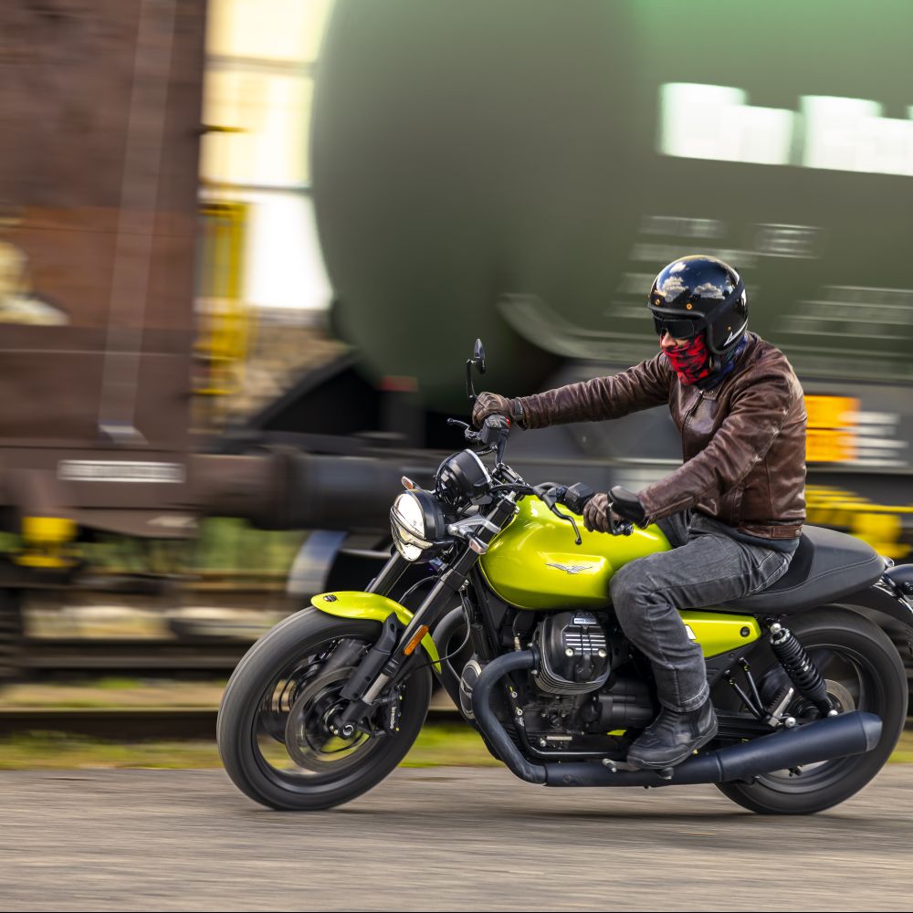 Moto Guzzi V7 Sport in Limonengrün fahrend in Schräglage