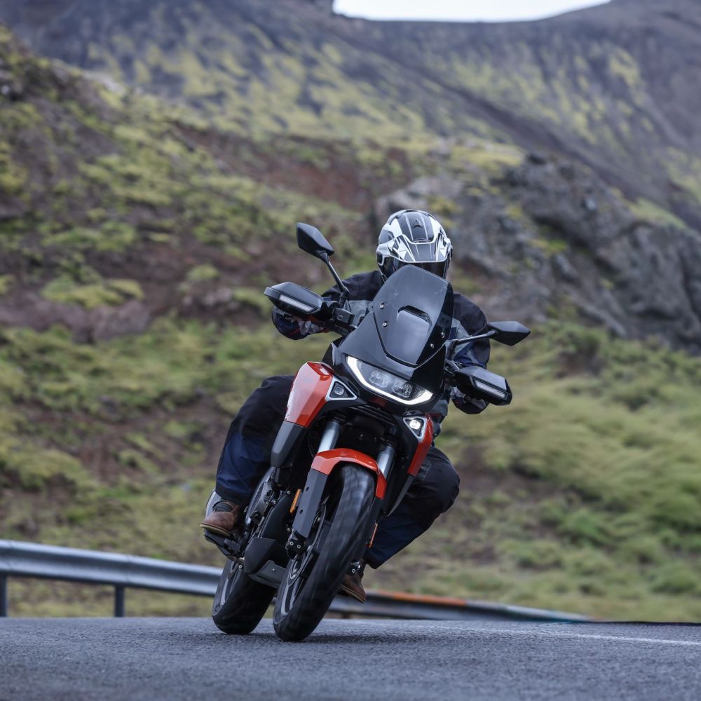 Norton Atlas 2026 in Orange fahrend schräg von vorne