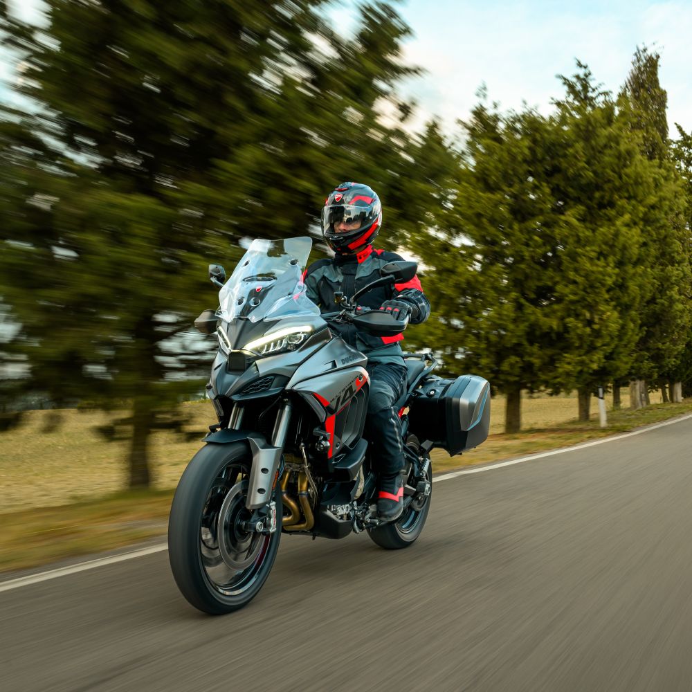 Ducati Multistrada V4 S Grand Tour Modelljahr 2027 in Grau fahrend von rechts nach links