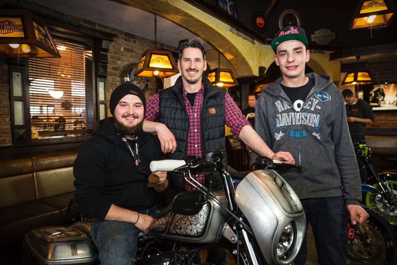 Felix und Markus – zwei Lehrlinge als Meister der Verwandlung; dazwischen Harley-Salzburg-Chef Christian Radauer.