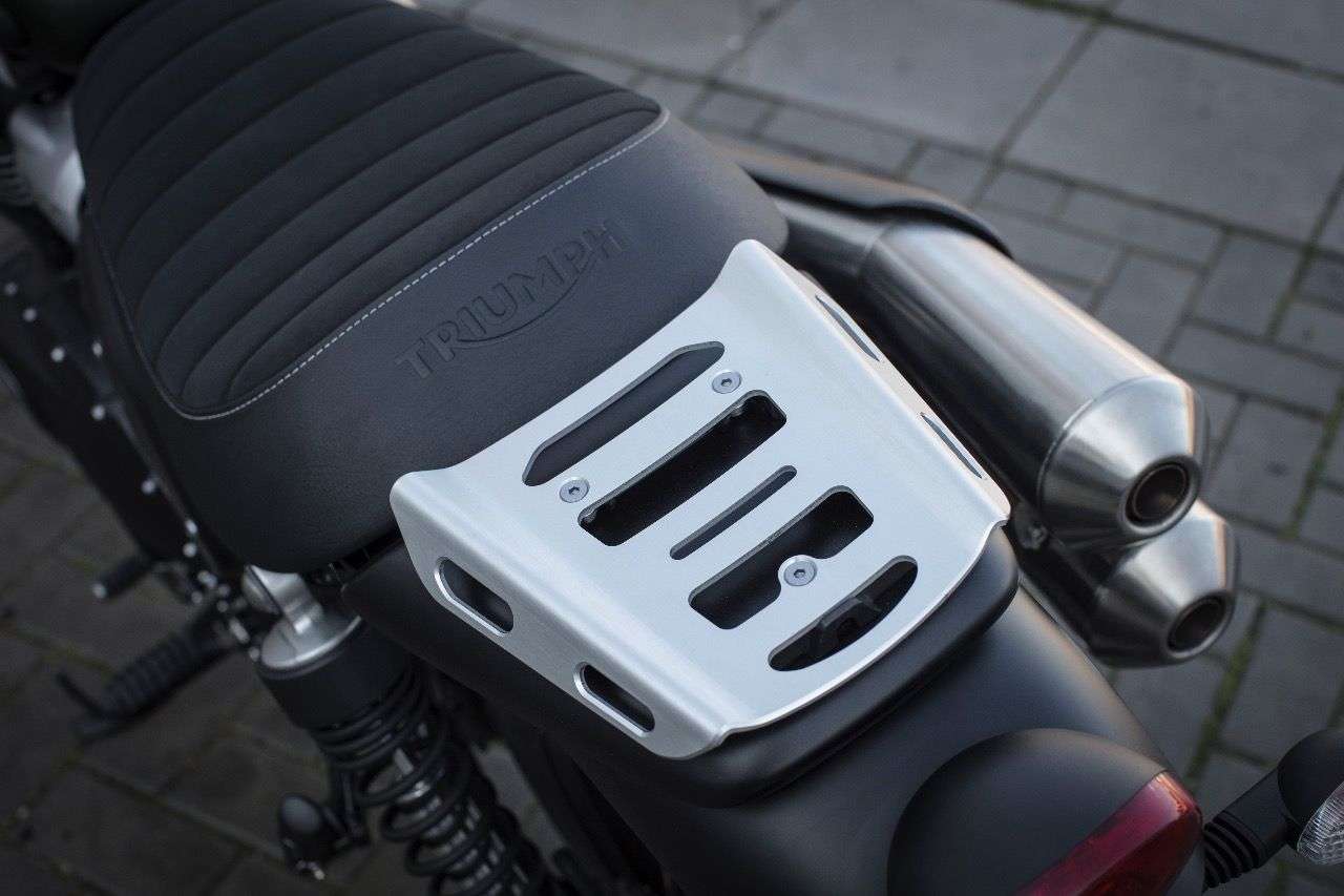 Der kleine und nicht besonders bequeme Soziussitz der Triumph Scrambler kann ruckzuck gegen einen serienmäßig mitgelieferten Alu-Gepäckträger getauscht werden.